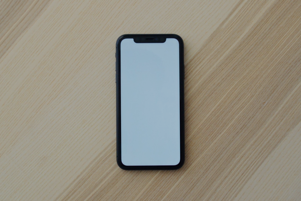 A white iPhone on a wooden table, showing that mobile-friendliness is critical when improving your website’s call-to-action Caption: Mobile devices now account for more than half of all internet traffic, so consider mobile-friendliness when improving your website’s call-to-action.